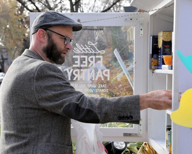 Michael Reinmiller restocks the Little Free Pantry