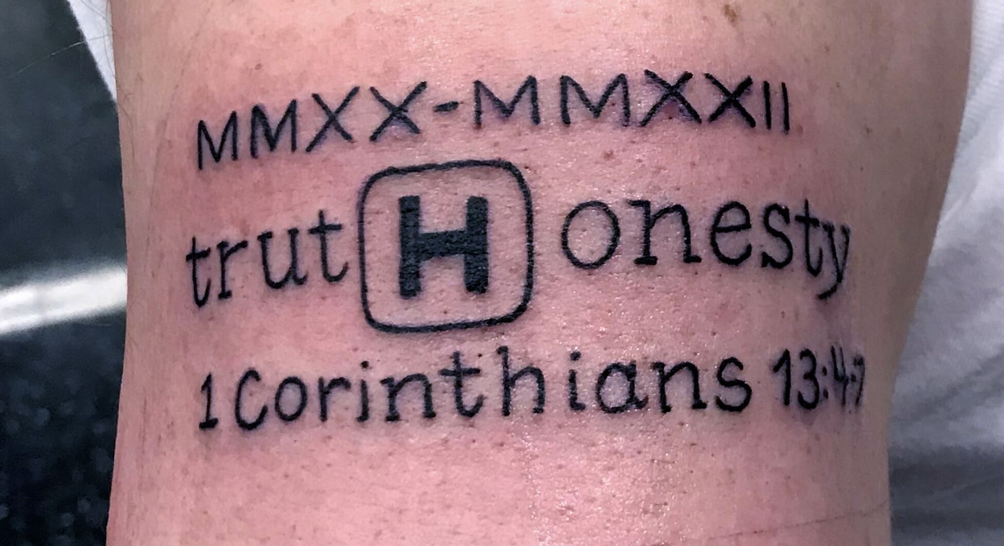 Foot tattoo saying 1 Corinthians 13