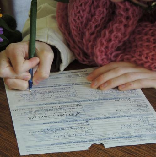 Kortnie signs the papers for her vehicle