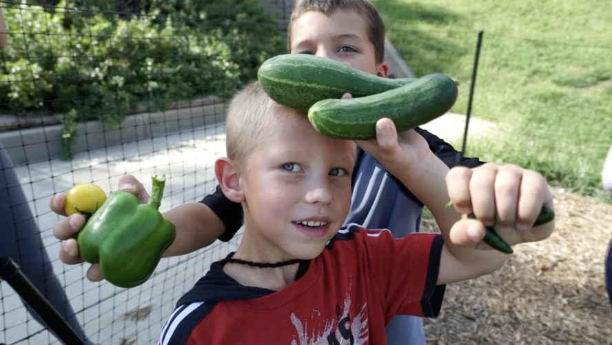 CLC kids with veggies from a garden