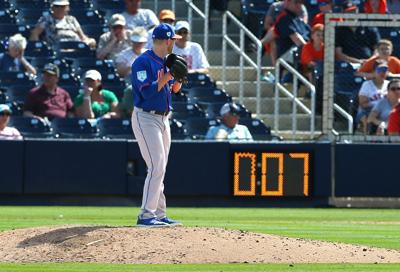 In this photo from March 11, 2019, Eric Hanhold of the New York Mets gets set to deliver a pitch as the pitch clock counts down during the ninth inning of a spring training baseball game against the Houston Astros at Fitteam Ballpark of the Palm Beaches...