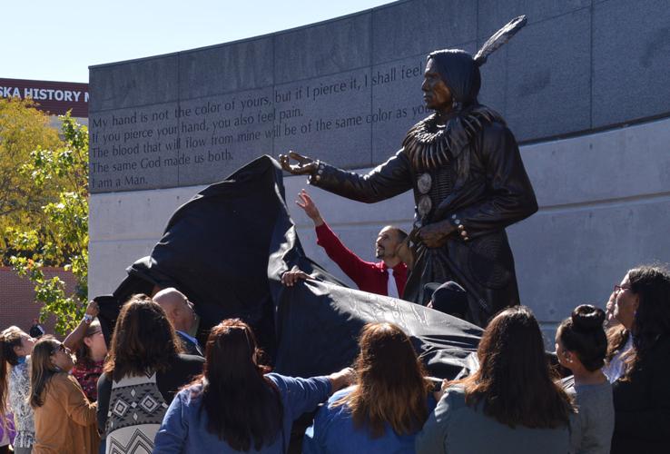 Unveiling with sculptor reaching in background