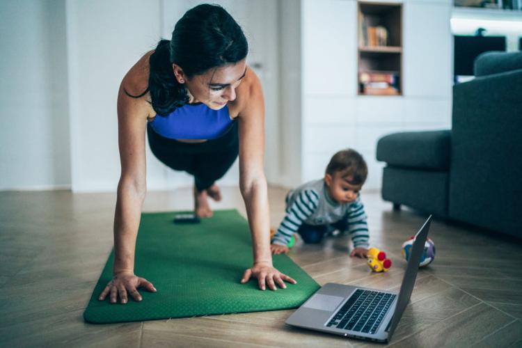 A mom works out at home to an online class