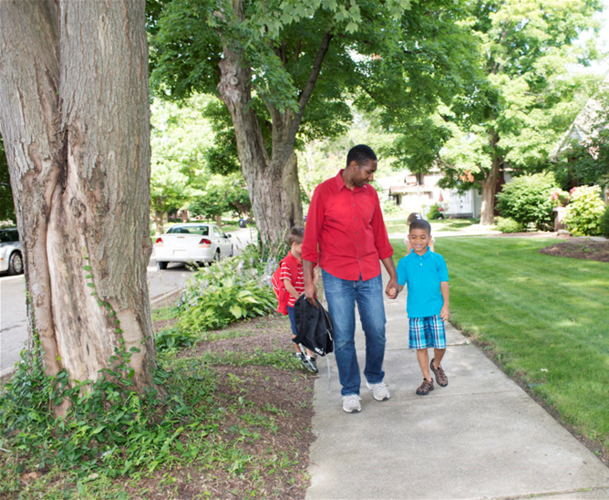 Dad walking kids to school