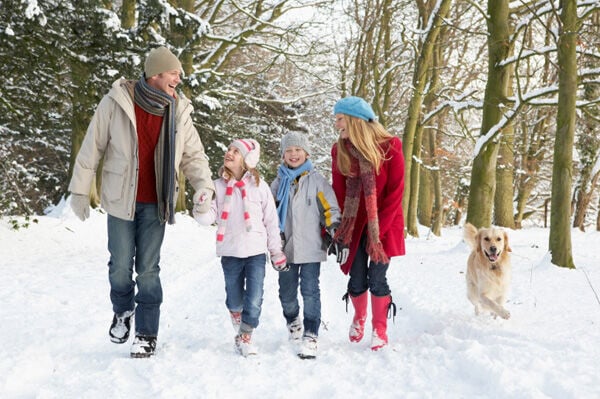 Family walking with dog in snow