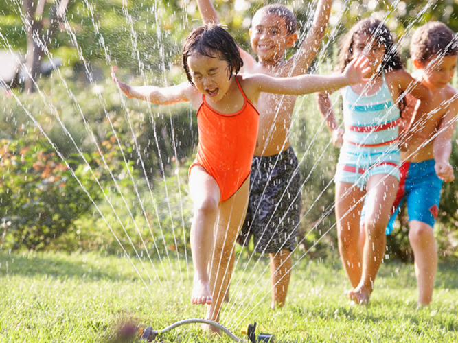 Kids running through sprinkler