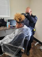 A Racine Police officer gives a haircut