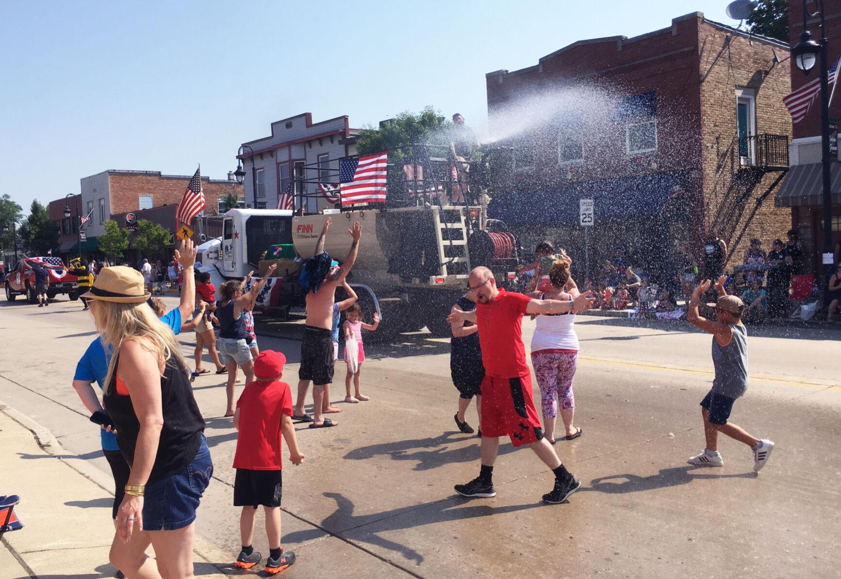 Parade float shoots water on spectators during hot Fourth of July parade