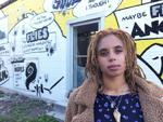 Kelsey Marie Harris poet in front of mural depicting her poem