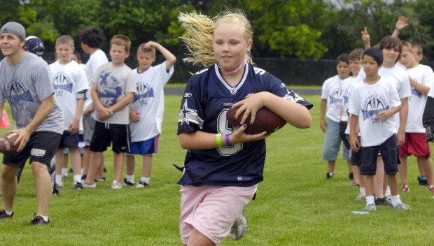 Candice Romo, wife of Dallas Cowboys quarterback Tony Romo, hands out  headbands she had bought for the girls registered during Romo' annual  football fundamentals camp at Burlington High School, Wednesday June 22