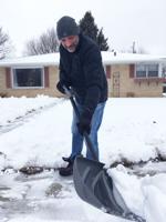 Kurt Lakatos of Burlington shovels snow outside his home