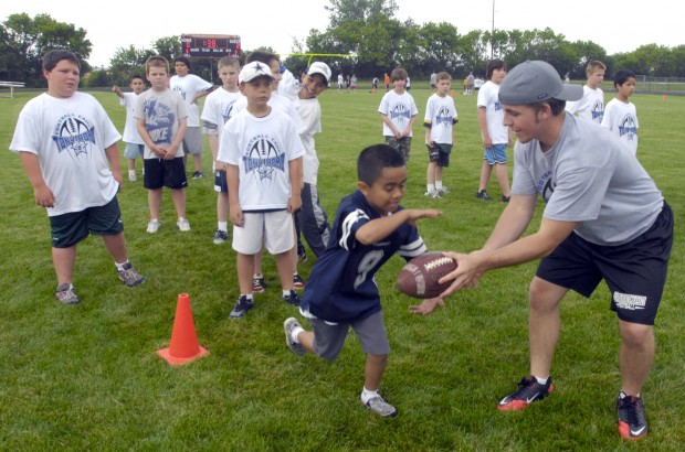 Candice Romo, wife of Dallas Cowboys quarterback Tony Romo, hands out  headbands she had bought for the girls registered during Romo' annual  football fundamentals camp at Burlington High School, Wednesday June 22