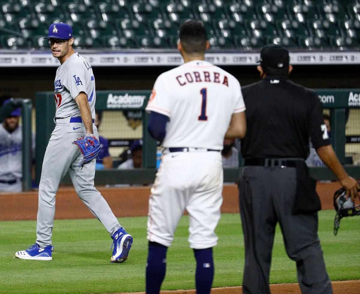 Joe Kelly #17 of the Los Angeles Dodgers has a word with Carlos Correa #1 of the Houston Astros as he walks off the mound after a series of high inside pitches in the sixth inning at Minute Maid Park on July 28, 2020 in Houston, Texas. Both benches emptied.