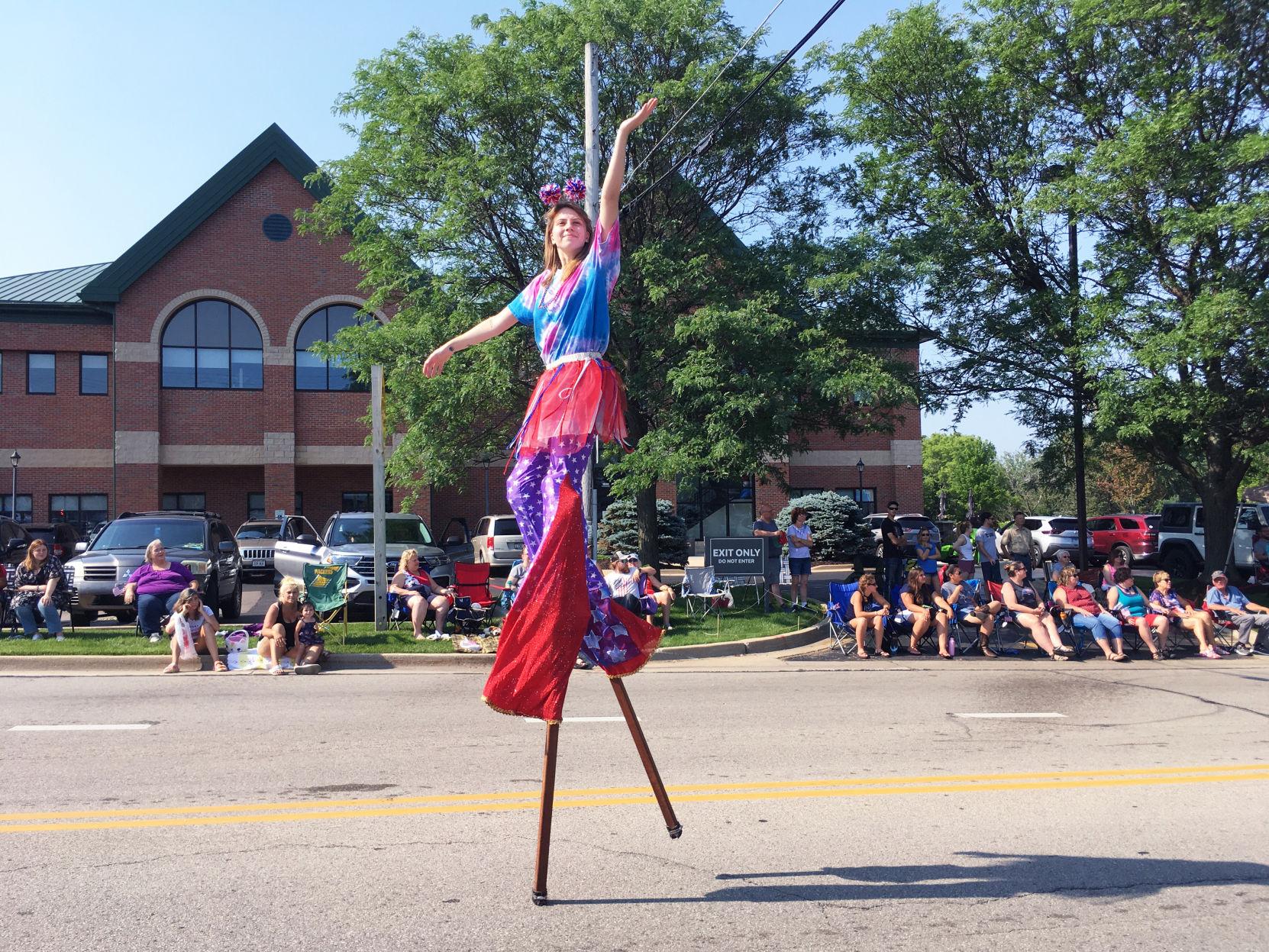 Performer on stilts waves to crowd