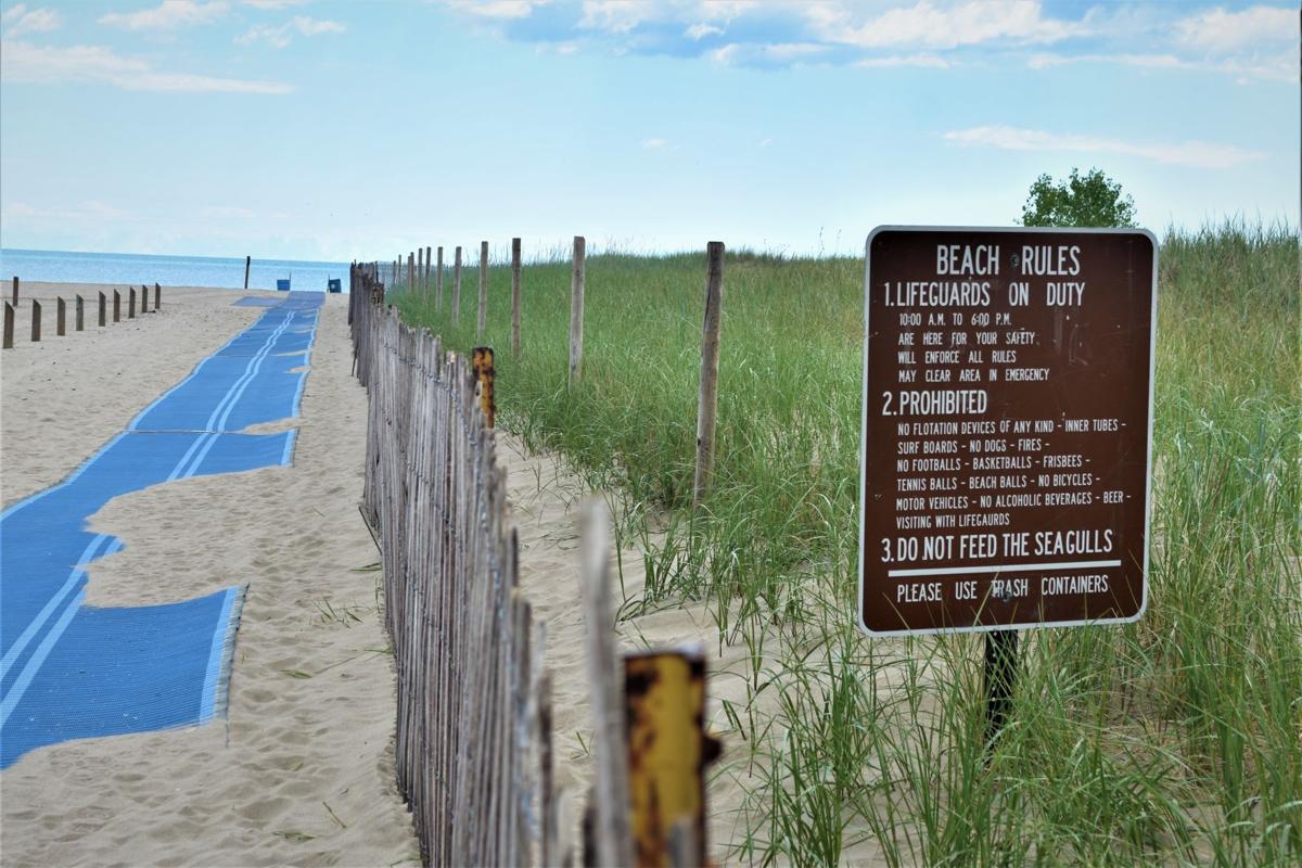 Beach rules sign by blue trail