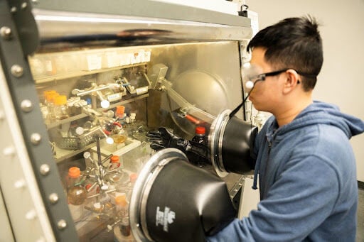 Student wearing goggles using a machine in the Jackson lab
