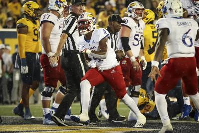 Kansas football sophomore running back Devin Neal after a play against West Virginia with other players on the field