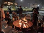 A group of people relax by one of the bonfires on Riviera Beach