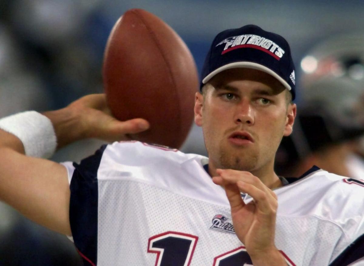 FILE - In this Feb. 3, 2002, file photo, New England Patriots players reach  out to touch the Vince Lombardi Trophy after the Patriots defeated the St.  Louis Rams 20-17 to win