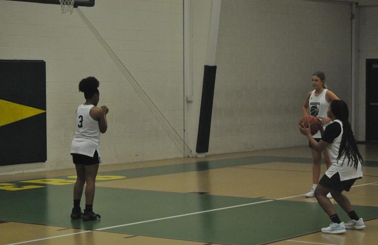 Three UHA Lady Blazers line up along the key as they practice a free throw routine