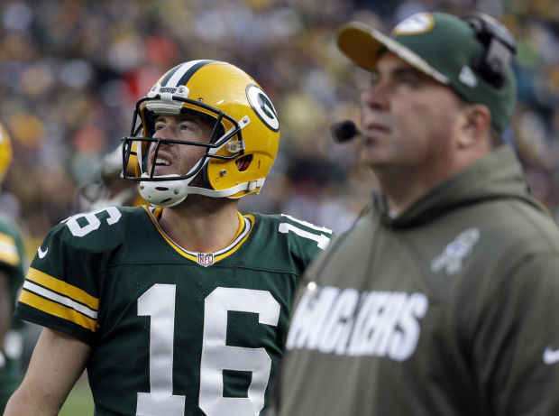 Green Bay Packers' Mike McCarthy holds a team helmet after being