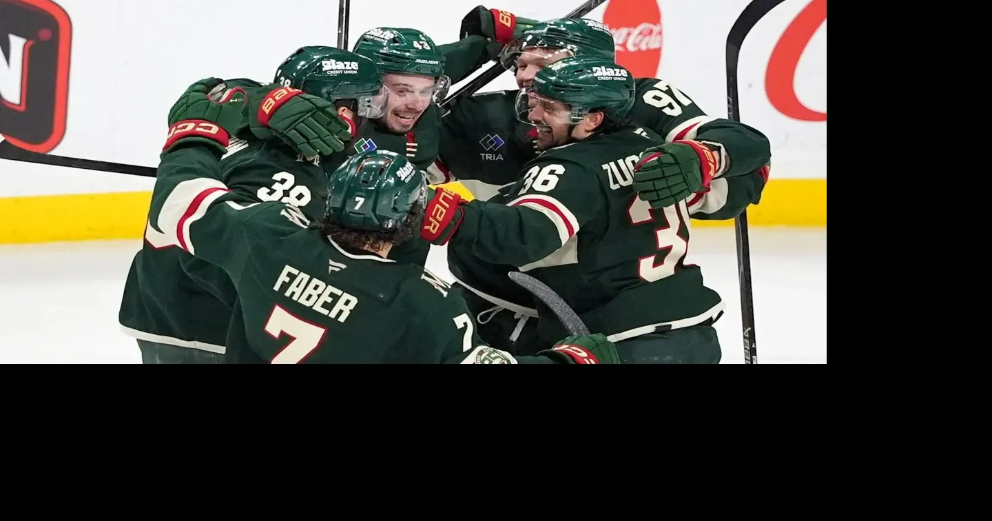 Wild defenseman Quinn Hughes celebrates with teammates