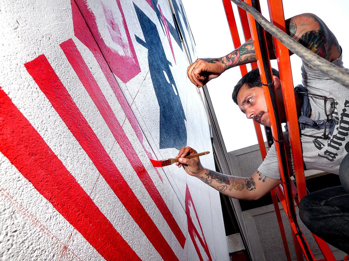 La Crosse mural artist gives downtown 'Helping Hands'