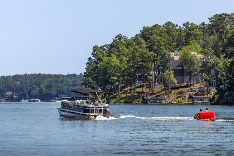 Family boating, pontoon pulling a tube