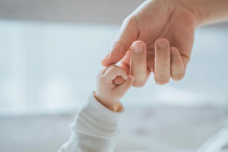 Baby's Hand Holding Mother or Father's Finger