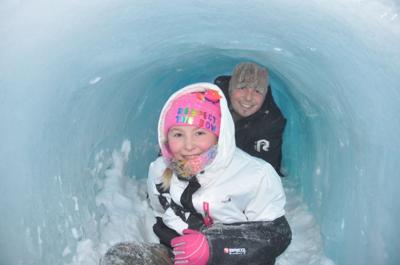 Adalyn Corwin, 9, and her father, Keith Corwin, complete their crawl through an ice castle tunnel