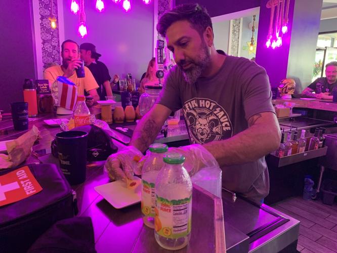 Kevin Singh prepares some hot sauce and chips for the contestants