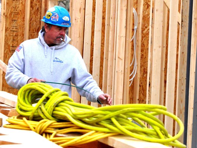 Balistic Contracting employee does some construction work on a two-story building