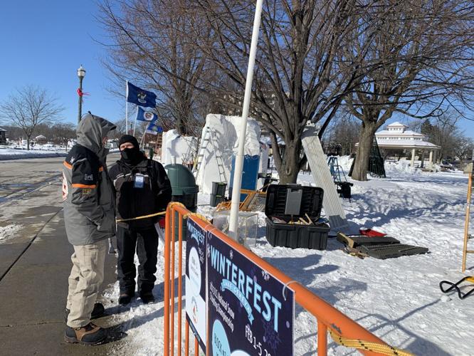 John White, right, member of Iowa snow sculpting team Burch St. Carvers talks to fellow snow sculptor Michael Sponholtz