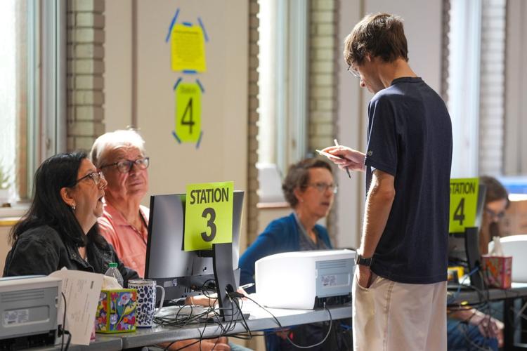 A voter looks at their identification card at Farragut Community Center at 239 Jamestown Boulevard during the first day of Early