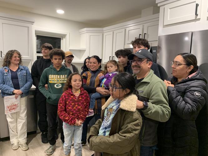 Marisol Rivera and her family celebrate the completion of the new Habitat for Humanity home during the house blessing ceremony