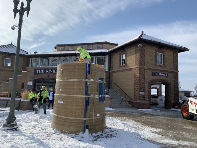 Snow is being packed into a large cylinder to create a snow block