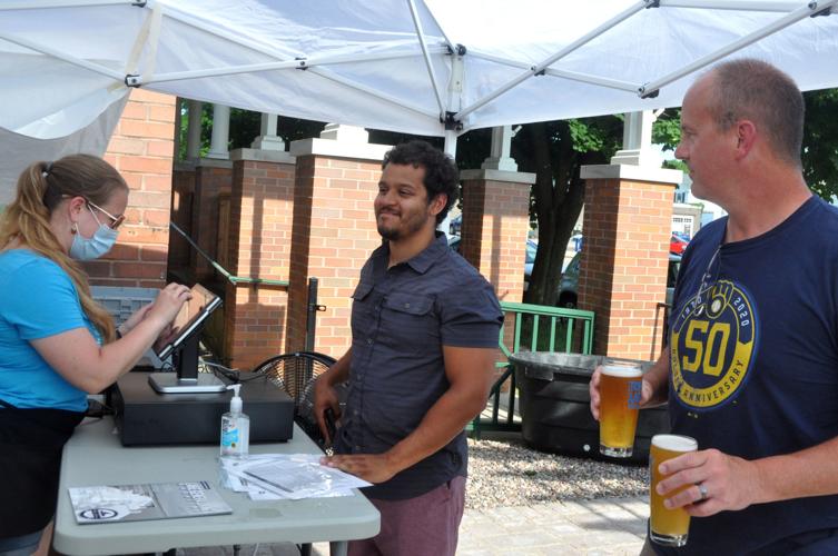 Kelly O'Malley, Topsy Turvey Brewery employee, rings up an order for Eli Hinton and Dave Rasmussen