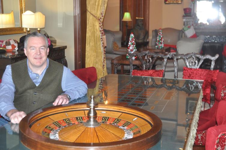Andrew Frtiz, owner of the Baker House, sits next to the roulette wheel that is located in the gaming room of the home