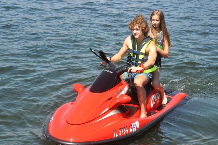 Logan and Hope Ieler of Geneva, Illinois prepare for a ride on their water scooter