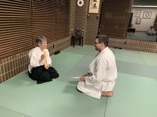 Instructor Dianne Costanzo presents Seth Klosinski with a promotion