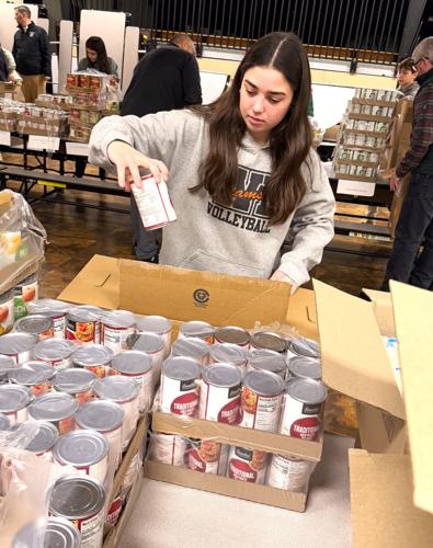 Williams Bay High School sophomore Lauren Sikes packs a holiday food box