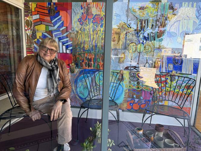 Ausrine Kerr poses with artwork she designed at Vintage and Modern Books