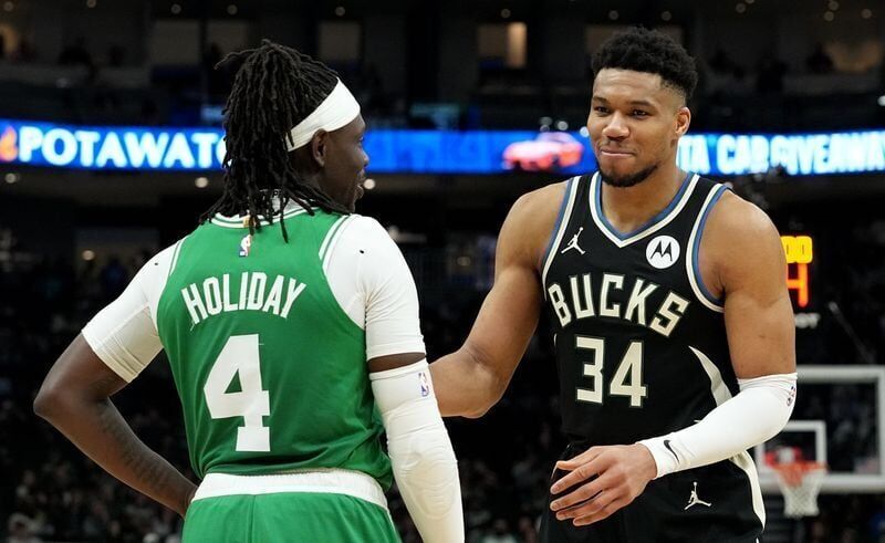 Bucks forward Giannis Antetokounmpo jokes around with former teammate Jrue Holiday during a game April 9, 2024, at Fiserv Forum. The Bucks owe the New Orleans Pelicans draft compensation through 2027 as part of the Holiday trade.