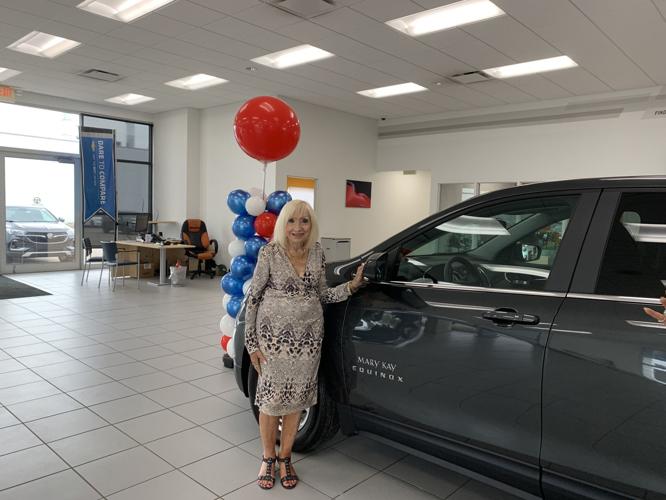 Eileen Fricke poses with her new Chevy Equinox that she received from the Mary Kay company
