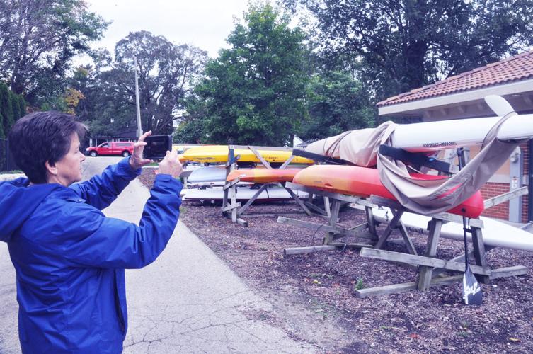 Harbormaster Linda Frame takes photos of a kayak that has been left uncovered.