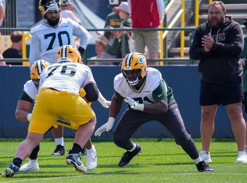Packers offensive linemen Josh Gesky (76) and Anthony Belton (71) run through a drill during the second day of training camp July 30.