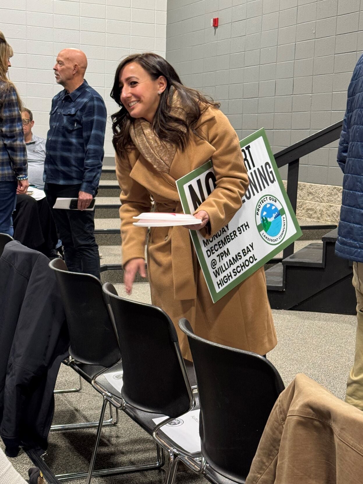 Williams Bay resident Jacquelyn Romando hands out protest signs