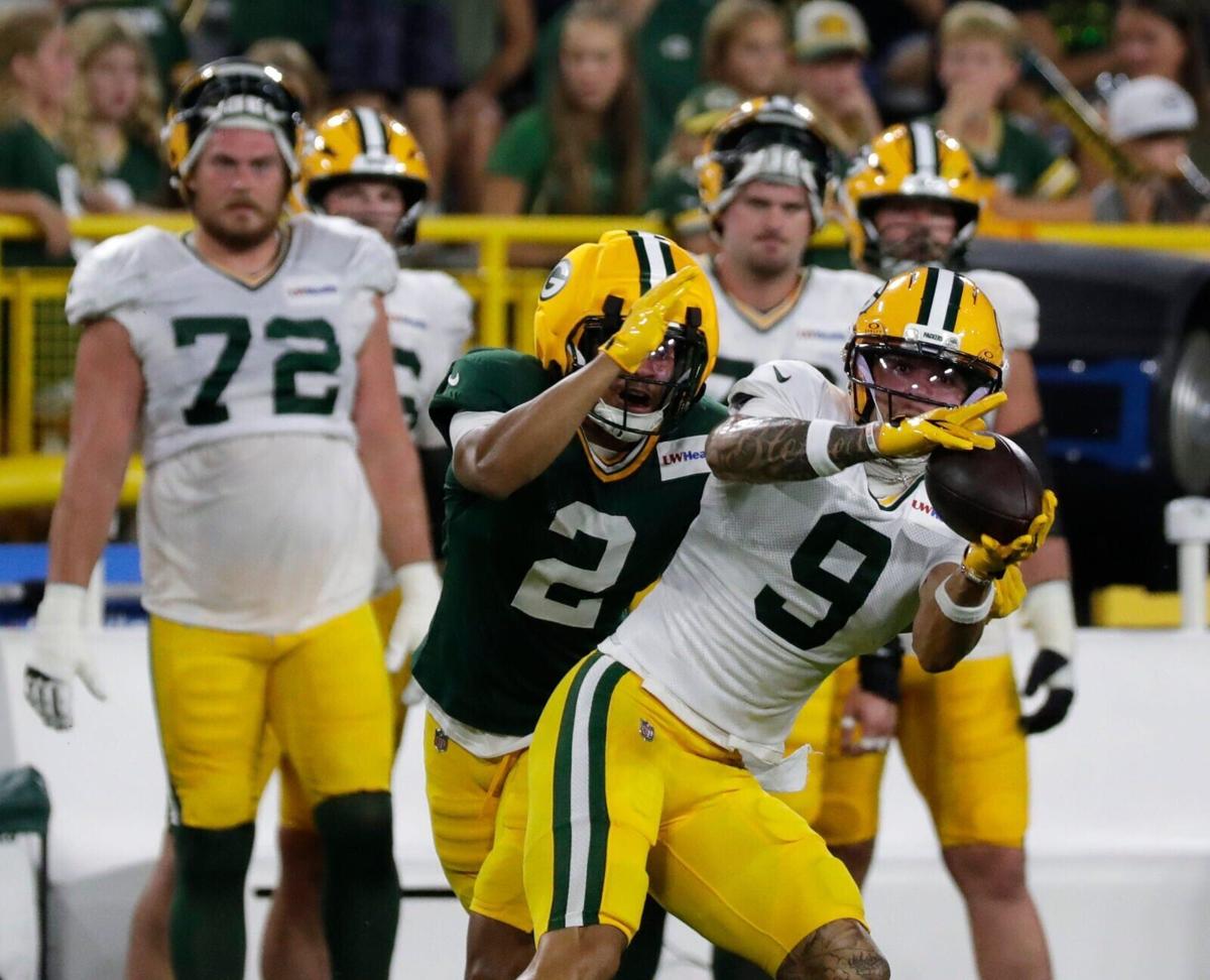 Green Bay Packers wide receiver Christian Watson (9) catches a pass with pressure from cornerback Brandon Cisse (2) during Green