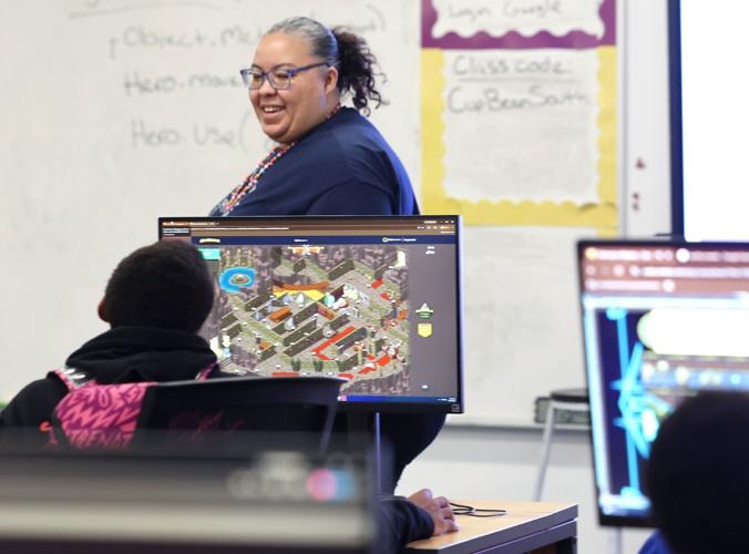 One City teacher D.J. Meadows works with students on coding lesson