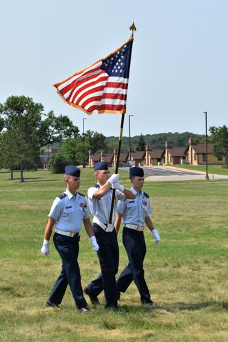 Cadet Josiah Harder carries the American flag during ceremony
